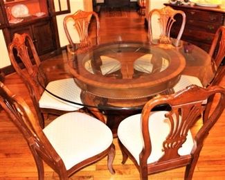 Glass top table shown with six shield back chairs.