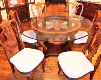 Glass top table shown with six shield back chairs.