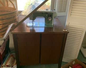 #54	Blue Deluxe Sewing machine in a mid-century Cabinet 	 $125.00 

