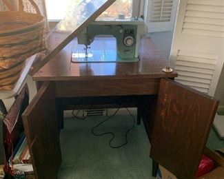 #54	Blue Deluxe Sewing machine in a mid-century Cabinet 	 $125.00 
