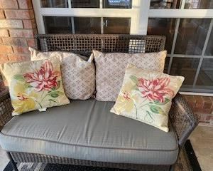 4-piece outdoor wicker porch set includes Love Seat, 2 side chairs, & coffee table w/ glass top & bottom shelf. All cushions & pillows are included & 5 x 7' outdoor rug.