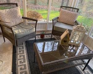4-piece outdoor wicker porch set includes Love Seat, 2 side chairs, & coffee table w/ glass top & bottom shelf. All cushions & pillows are included & 5 x 7' outdoor rug.