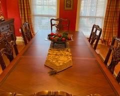 Picture of formal dining room table with wooden chairs around it and 2 leaves inserted.