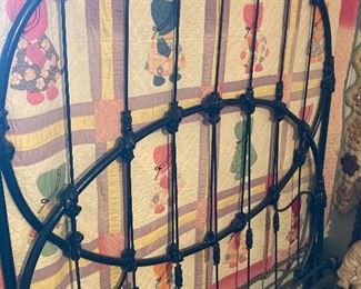 Antique iron headboard and footboard; handmade quilt