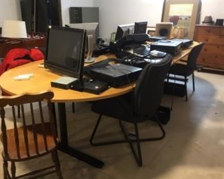 Large office table with chairs and many monitors 