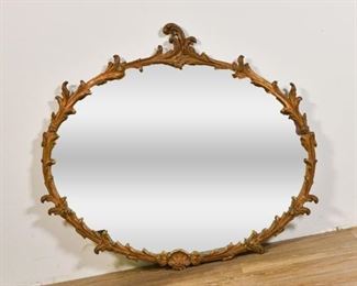 62	Carved Gold Oval Mirror	Carved gold oval mirror with branches and florets. Small crack to lower left branch. Small repair to lower right branch. Back of mirror has cardboard secured by tape. 37 1/2" H x 41 1/2" W x 1 1/2" D.
