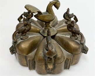 91	Kumkuma Brass Indian Spice Box	Kumkum box, a traditional celled container for holding Kumkuma - different colored powders used for social and religious markings in Hindu culture, often made of Turmeric. Six covered drop-form cells, with hinged lids and bird head finials Bird-form central finial. Made of thick bronze. Six legs. Raj India, 19th century. 3 1/2"-diameter.
