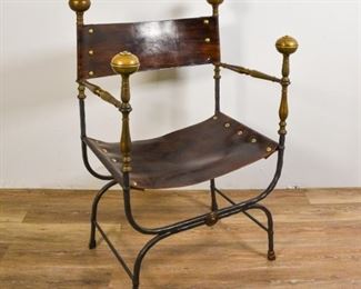 136	Spanish Savonarola Chair	Spanish Savonarola chair. Spain, Early 20th Century. Wrought iron frame with brass bulb terminals, leather back and seat, diminutive brass paw feet. Scratches and wear to seat, wear to terminals. 41" H x 25" L x 21" D
