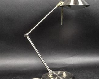 155	Contemporary Chrome Desk Lamp	Contemporary chrome desk lamp. Early 21st Century. Chrome body, angled neck, light source pivots with brass turning rod. Lamp has been tested and works. Some wear to base. When fully extended: 26" H x 7 1/2" diameter of base
