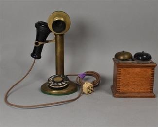 161	Brass Candlestick Rotary Phone and Ringer	Brass candlestick rotary phone and wood box ringer. Label in the center dial panel: "Orange 5- 1889". "Patented Jan 26th 1918 to Sept 21st 1920" on bottom rim. Loss of paint to ringer bell. Phone: 11" Height. Ringer box: 5 1/4" L x 4 1/4" W x 4 5/8" H.
