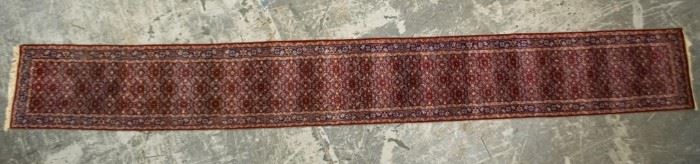 172	Persian Runner	Persian runner. Fringed ends, red and blue, repeating diamond medallions throughout. 2'6" x 20'4"
