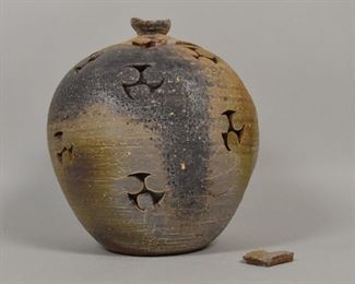 212	Japanese Pottery Jar	Japanese jar with tomoe design. Brown oribe glaze with feldspar inclusions. 12 1/2" H. Lid is cracked on 1 side.
