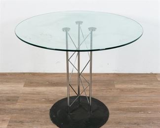 227	Modernist Glass Pedestal Table	Modernist glass pedestal table. Mid 20th Century. Black metal base, triangular-constructed chrome pedestal, fixed tempered glass top. Some wear to glass and base. 30" H x 35 1/2" diameter of glass top
