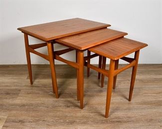 228	Set of Danish Modern Nesting Tables	Set of Danish Modern nesting tables. Denmark, Mid 20th Century. Teak, dowel feet, beveled tops. "MADE IN DENMARK" stamp on underside of smallest table. Legs of largest table are slightly loose and warped. 18" H x 23" L x 15 1/2" W
