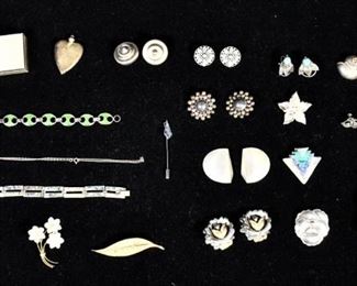 290	Grouping of Sterling Objects	Grouping of sterling objects. 20th Century. Most are marked Sterling, green clasp bracelet is marked .900. Objects of interest include a violin pin, a heart, and a sun pin. Total weight of all objects is 330.69 grams, this also includes the non-sterling parts of the objects. 3/4" H x 3 1/2" L x 2" D- measurement of sterling pill box.
