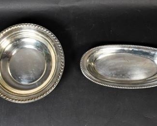 303	Sterling Silver Bread Plate and Bowl	R.H Macy & Co bread plate. 12 1/4" L x 5 3/4" W x 1 1/2" H. Wallace bowl with scalloped rim. Marked on the underside "H102". 10 1/4" Diameter x 2 1/8" H. 441.94 grams total.
