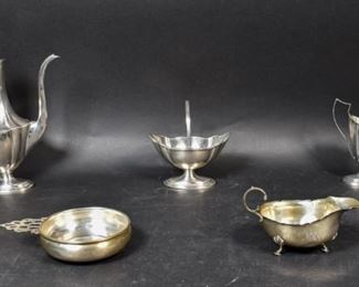 306	Collection of 5 Sterling Silver Items	Collection of 5 sterling items: a Gorham handled candy dish, a creamer, a porringer, coffee pot, and a Birmingham England 1908 gravy boat. Coffee pot: 10 1/2" H x 8 1/2" W. 885.54 grams total, including the wooden handle of the coffee pot.
