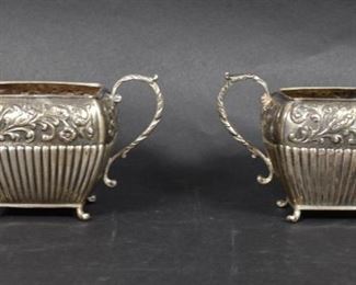 319	Dutch Silver Sugar & Creamer	Dutch silver sugar and creamer, with repousse floral decoration. Each with Dutch silver 2nd standard lion passant, Minerva hallmarks on side, and illegible maker's marks to undersides. Circa 1948. Creamer 4 1/2"L x 3"H including handle, 270.2 grams total.
