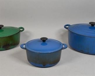 347	Grouping of Le Creuset Enamel Cookware	Grouping of Le Creuset enamel cookware. French, Mid 20th Century. No. 29 green Dutch oven, no. 35 blue Dutch oven, and a blue stockpot marked "D" underneath lid. All marked Le Creuset on black knobs. Wear and scratches throughout all. 7" H x 17" L x 12" D of No. 35 Dutch oven
