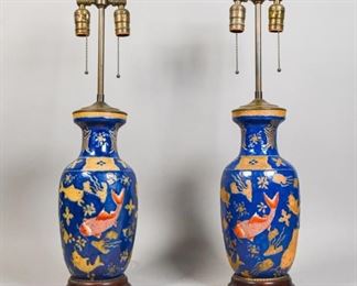 352	Pair of Chinese Porcelain Lamps	Pair of Chinese blue porcelain lamps with Koi fish with additions of water plants, set on wooden base, with brass lamp fitting. 27" H x 5 3/4" Diameter.
