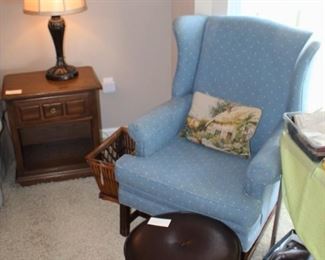 Nightstand, lamp, ottoman and wingback chair.
