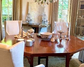 Gorgeous hexagonal walnut dining table with asian accents on the legs and five upholstered wing back dining chairs on casters