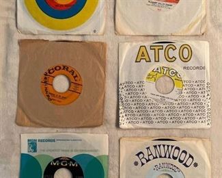 Six 45 rpm records featuring Helen Reddy, Monkees, Buddy Holly, Herman's Hermits, and more