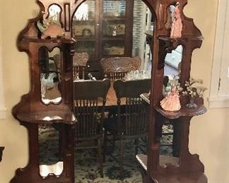 Antique walnut at this year. Carved crest, cut out shelf supports, mirrored displays, beveled Marble top base. As good as it gets!
