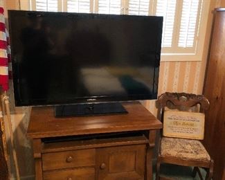 Samsung 46" flat screen television, antique empire style cabinet converted to use as a television stand.  Drawer removed to house electronics.