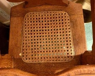 Early 1900s canned tiger oak highchair. Seat and seat back are in perfect condition. On metal rollers. Made in USA.