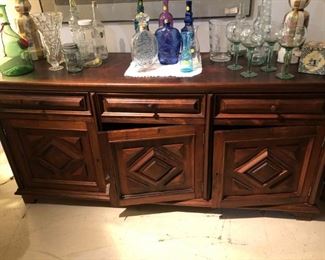 Brazilian carved door buffet cabinet.  Lots of vintage and modern glass bottles  