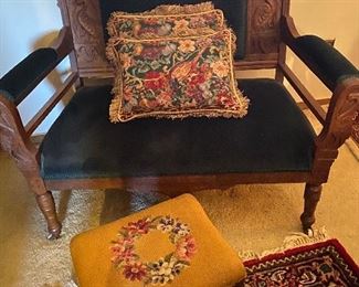 Green velvet small settee with a pair of needlepoint pillows and a needlepoint gold footstool. 