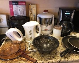Small appliances including hand mixer, Acme Supreme Juicerator, coffee maker & grinder, enamel pot & colander, skillets