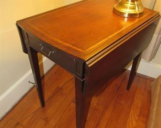 A pair of these leather top drop-leaf tables