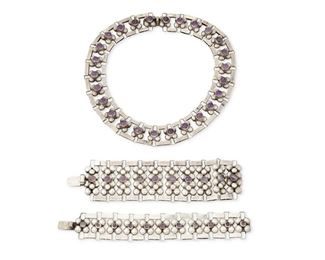 18
A Set Of Fred Davis Silver And Amethyst Jewelry
Pre-1948; Mexico City, Mexico
Each stamped with conjoined FD for Fred Davis; Further stamped: Silver / Mexico; Necklace further stamped: [Eagle 22]
Comprising a collar necklace with amethyst cabochons set on linked clusters of silver half spheres, together with a similar style double-wide clasp bracelet and a narrow clasp bracelet

3 pieces
Necklace: 16.25" L x 1" H; Bracelets: 6.75" L x 1.875" W and 7.25" L x 1.125" W
237.1 grams gross
Estimate: $1,500 - $2,000