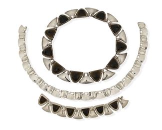 20
A Group Of Fred Davis Silver, Obsidian, And Onyx Mask Jewelry
Pre-1948; Mexico City, Mexico
Each stamped with FD for Fred Davis; Each variously stamped: Sterling / 925
Comprising a carved obsidian and onyx mask necklace (17.5" L x 1" H) with matching obsidian bracelet (7.25" L x 0.875" H), together with a silver mask necklace of similar design (18" L x 0.625" H)

3 pieces
246.5 grams gross
Estimate: $1,200 - $1,800