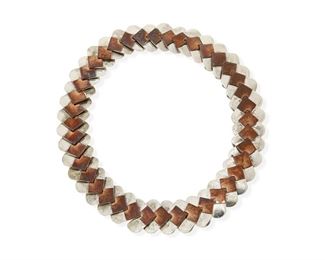 40
A Héctor Aguilar Silver And Copper Necklace
1948-1962; Taxco, Mexico
Stamped with conjoined HA for Héctor Aguilar; Further stamped: .940 / Taxco Mexico / [Eagle 9]
A collar necklace formed of silver and copper chevron links with a hook clasp
17" L x 1" H
167.6 grams gross
Estimate: $800 - $1,200