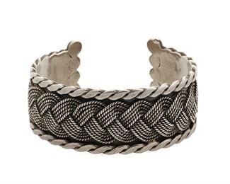 57
A Héctor Aguilar Braided Silver Cuff Bracelet
1940-1945; Taxco, Mexico
Stamped: HA / Taxco / 940; Etched: Mexico
A cuff with a heavy rope braid overlay within a border of flattened twisted wire, finished with ball terminals
6.5" total inner C x 1.25" H, wrist opening: 1.125"
73.6 grams
Estimate: $500 - $700