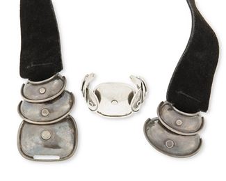 68
A Héctor Aguilar Silver Armadillo Belt And Cuff
1943-1948; Mexico
Each stamped: HA / Made in Mexico / Sterling
Comprising a black suede leather belt with attached silver latch buckle (buckle: 2.75" H x 6.5" W; belt: 33.25" L, with buckle 2.125" H) and a silver cuff bracelet in a similar design (6.5" total inner C x 2.125" H, wrist opening: 1.675")

2 pieces
226.5 grams gross
Estimate: $600 - $800