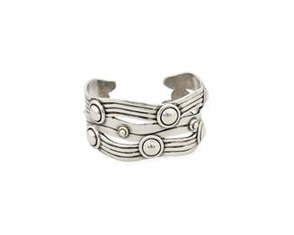 106
A William Spratling "River Of Life" Silver Cuff Bracelet
1940-1946, First Design Period; Taxco, Mexico
Stamped for William Spratling; Further stamped: Made in Mexico / Silver
Designed as silver waves with Aztec rings
6.625" total inner C x 1.5" H, wrist opening: 1"
85.9 grams
Estimate: $1,000 - $1,500