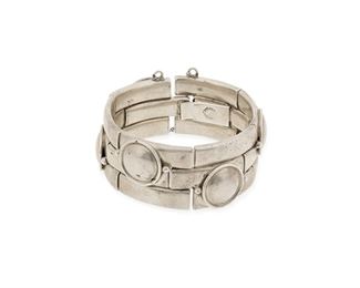 110
A William Spratling Silver Bracelet
1964-1967, Third Design Period; Taxco, Mexico
Stamped for William Spratling; Further stamped: Taxco / Mexico / .925
A bracelet designed with links of applied raised discs and stepped rectangles, with clasp closure and chain guard
7" L x 1" H
101 grams
Estimate: $500 - $700