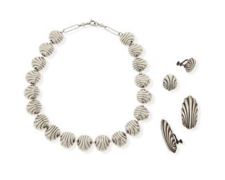 115
A Group Of William Spratling Silver Shell Jewelry
1933-1939 and 1940-1946, First Design Period; Taxco, Mexico
Each stamped for William Spratling; Further stamped: Made in Mexico / Silver
Comprising a shell link necklace with matching ear clips and two additional larger shell ear clips

5 pieces
Necklace: 16.5" l x 0.75" H; Ear clips: 0.75" L and 1.5" L
72.0 grams gross
Estimate: $700 - $900