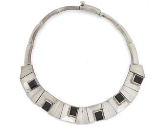 155
An Antonio Pineda Sterling Silver And Onyx Necklace
Post-1953; Taxco, Mexico
Stamped with crown mark for Antonio Pineda; Further stamped: Hecho en Mexico / 970
Designed with silver geometric links accented with faceted rectangular onyx
14.75" L x 0.75" H
127.5 grams
Estimate: $1,200 - $1,800