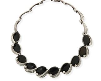 159
An Antonio Pineda Silver And Onyx Necklace
1962-1963; Taxco, Mexico
Crown mark for Antonio Pineda / [Eagle 3]; Further stamped: Los Castillo / Soc Coop Scl Sec 2
A stylized wave link necklace set with oval onyx
15" L x 0.75" H
104.0 grams
Estimate: $800 - $1,200