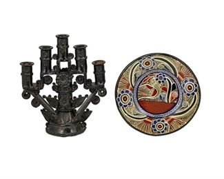 182
Three Mexican Pottery Items
Three works:

A Tlaquepaque pottery effigy pitcher
Circa 1950; Tlaquepaque, Mexico
Possibly inscribed: Recuerdo de Calpulalpan [further inscribed illegibly]
The footed pitcher standing on four raised feet with portrait mask to spout and polychrome floral necklace
13" H x 8" W x 10" D

A Michoacán pottery candelabrum
Second Half 20th Century; Michoacán, Mexico
The candelabrum with applied floral roundels issuing five arms finished in a high gloss black glaze on terracotta foundation
12" H x 11" W x 4.5" D

A Michoacán pottery plate
Second Half 20th Century; Michoacán, Mexico
The polychrome plate with an intricate floral border and central avian design
1" H x 10" Dia.

3 pieces
Estimate: $200 - $300