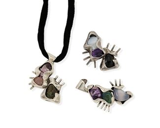 278
Three Salvador Terán Interchangeable Silver And Hardstone Pendants
1955-1970; Mexico
Each stamped: Salvador / 124; Two further stamped: Sterling / Mexico; One further stamped: [Eagle 36]
Each free-form modernist-style pendant/brooch is set with various colorful hardstones, each with pin on reverse and with one strung as a pendant on a black velvet cord with silver tips

3 pieces
Size range: 2.75" L to 3" L x 2" W approx.
111.5 grams gross
Estimate: $300 - $500
