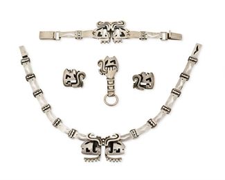 279
A Group Of Salvador Terán Silver Jewelry
Mid-20th Century; Mexico City, Mexico
Each stamped: Salvador / Sterling / Mexico; Further variously stamped: Silver / [Eagle 36] / 132 / [indistinct eagle]
Comprising a silver Mayan warrior-inspired collar necklace (14" L x 1.25" H), a matching bracelet (6.5" L x 1.325" H), a pair of screw-back earrings (1.125" L), and a money clip with chain ring to one end (1.125" H x 2.75" W)

5 pieces
142.9 grams gross
Estimate: $600 - $800