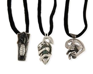 280
Three Salvador Terán Silver And Hardstone Pendant Necklaces
1955-1970; Mexico
Stamped: Salvador / Sterling / Mexico / [Eagle 36 or Eagle 3]; Further variously stamped with design number
A trio of pendants, each suspended on a black velvet cord with applied silver tips, one with hook closure, comprising a brooch/pendant of a standing figure in bone on a rectangular plaque No. 510 (2.75" H x 1.25" W); an abstract figure with a ponytail holding a green stone (3" H x 1.375" W); and a brooch/pendant of an abstract figure holding a dark stone No. 123 (2.5" H x 2" W)

3 pieces
118.8 grams gross
Estimate: $400 - $600