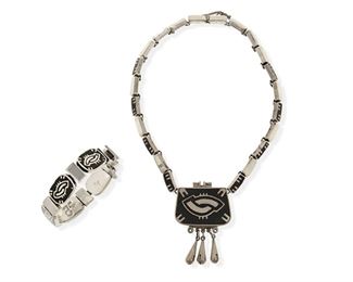 285
A Set Of Los Castillo "Onix Negro" Jewelry
1959-1965; Taxco, Mexico
Each stamped for Los Castillo; Further stamped: Onix Negro / Hecho en Mexico / [Eagle 15] / 43
Comprising a necklace of inlaid stone and silver links suspending an inlaid stone and silver pendant with silver dangles, and a link bracelet of similar design with clasp closure and chain guard

2 pieces
Necklace: 16.5" L x 3" H; Bracelet: 7.5" L x 0.625" H
139.1 grams gross
Estimate: $300 - $500