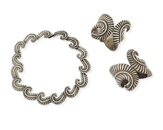 290
A Group Of Los Castillo Foliate Design Jewelry
1940-1945 and 1948-1950; Taxco, Mexico
Each stamped: Los Castillo / Taxco / Sterling; Each variously further stamped: Made in Mexico / Mexico / 238 / [Eagle 15]
Comprising an articulated link necklace and two cuff bracelets with spring hinges, all designed in an elaborate stylized feather/foliate motif

3 pieces
Necklace: 17" L x 1" H; Each bracelet: 6.5" inner C x 2.5" H
279.2 grams gross
Estimate: $700 - $900